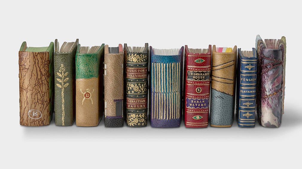 A selection of miniature books lined up next to each other.