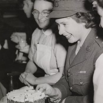 Photograph of Princess Elizabeth accepting a piece of cake at a tea party at the Royal College of Nursing
