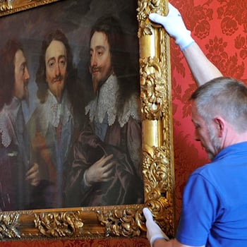 Painting being  moved by art handlers