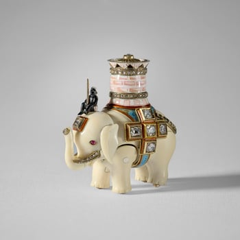 An ivory elephant with separate, jointed body legs and head, ridden by an enamel man sitting on its head and carrying a pink and white enamel castle with two  rose cut diamond set bands and a pierced upper rim, the top set with a 