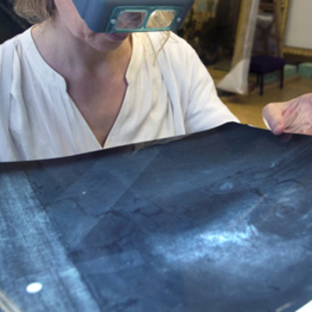 An infra-red image being looked at by a conservator