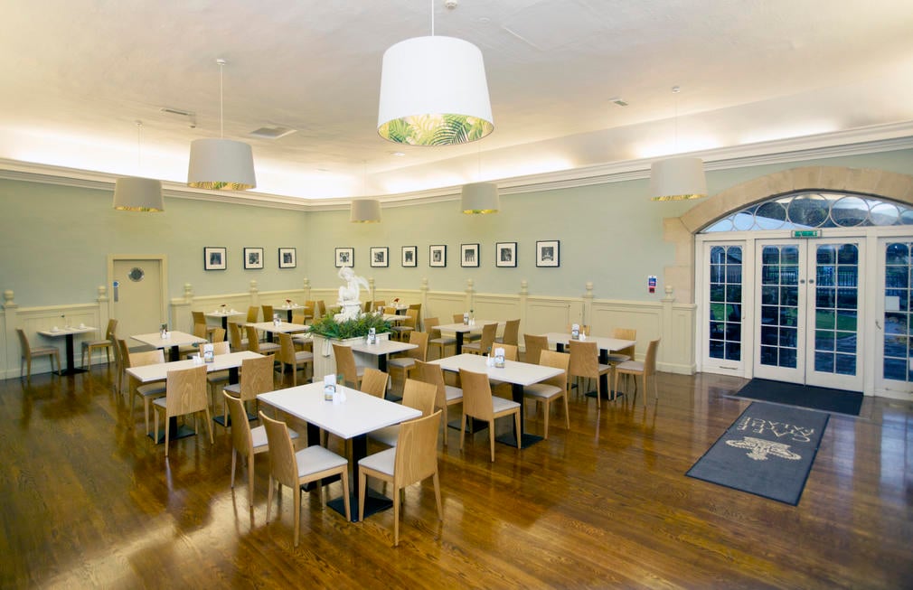 Polished wooden floors, wooden furniture and pale green walls in the Cafe