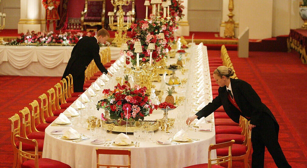 Staff members lay the State Banquet table, in the ballroom at Buckingham Palace.