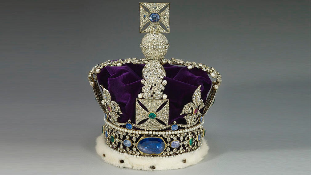 A crown set with thousands of diamonds, a purple velvet cap and a large sapphire in the centre