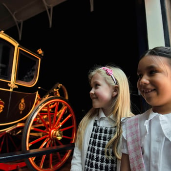 Children look at coach at the Royal Mews