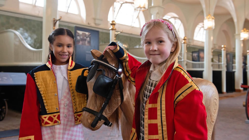 Children tacking up wooden horse