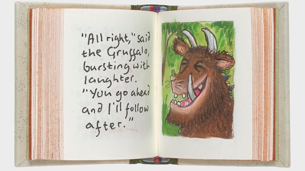 an open page of a tiny book with handwriting and picture of the Gruffalo