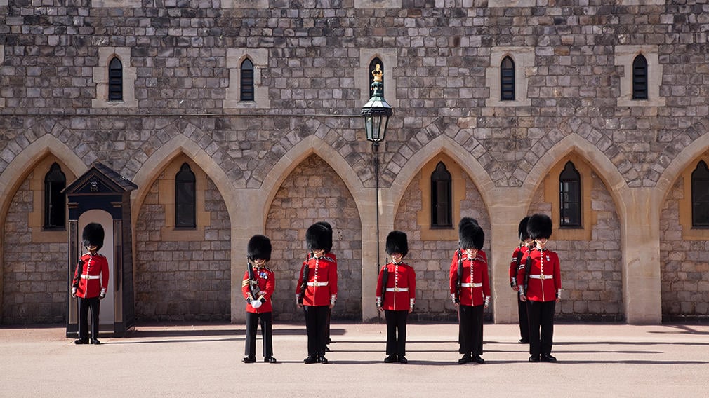 Guards stand in front of castle wall in Windsor Castle