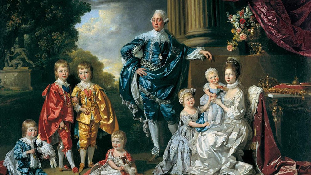 George III, Queen Charlotte and their six eldest children. Queen Charlotte is sitting wearing a white gown and holding an infant. In the background is a fictional garden with statues and columns.