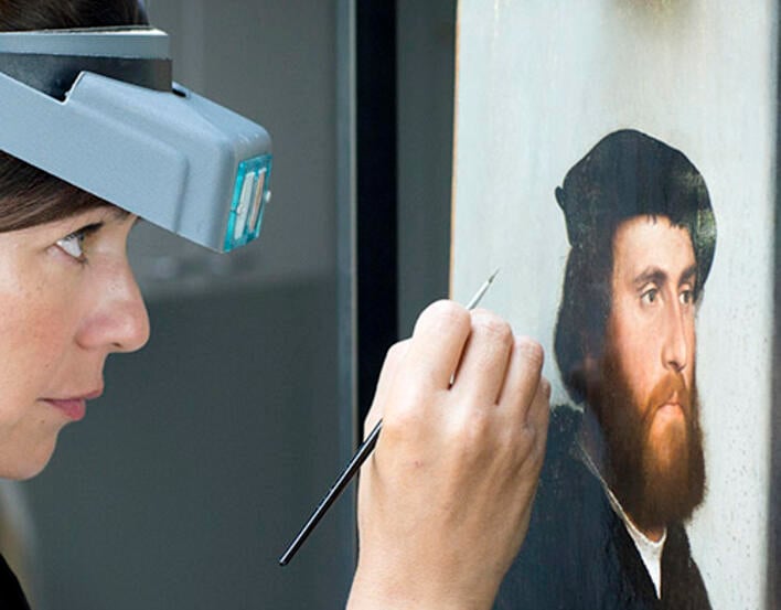 Conservator working on Hans of Antwerp with a brush