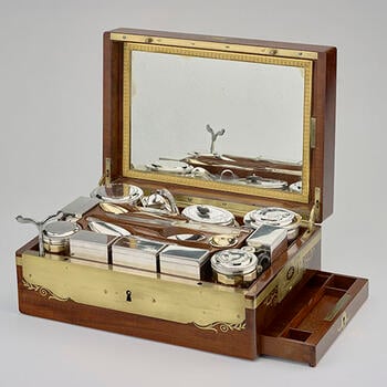 A silver and silver-gilt travelling service in a mahogany and brass-bound box, the lid inset with a brass shield engraved with the SN monogram of Stéphanie Napoleon (Stephanie de Beauharnais). The box has brass carrying handles and i