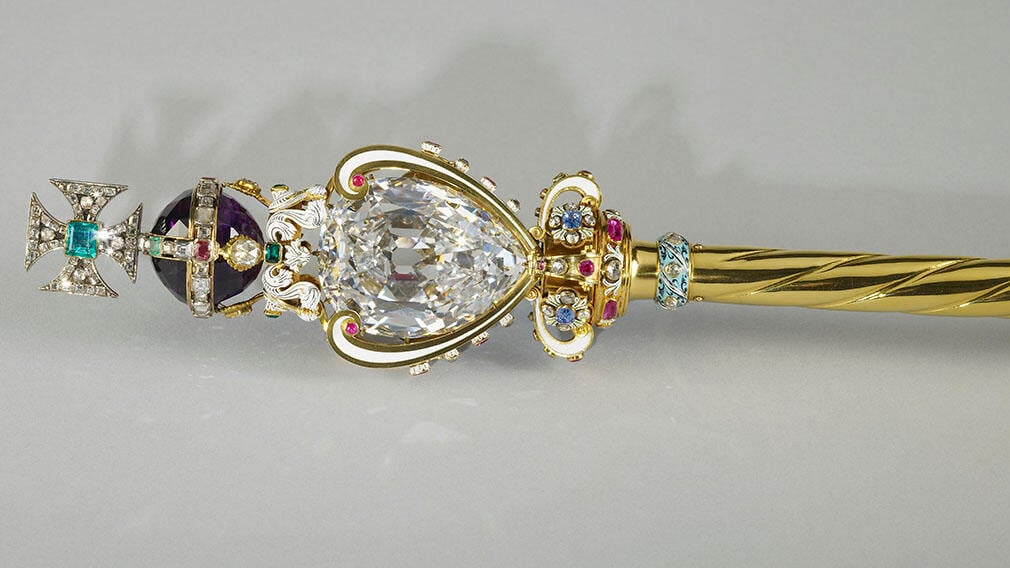 A gold rod topped with a large diamond and cross.