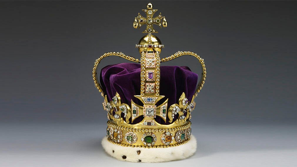 A gold crown set diamonds, rubies, amethysts and sapphires. It has a purple velvet cap.