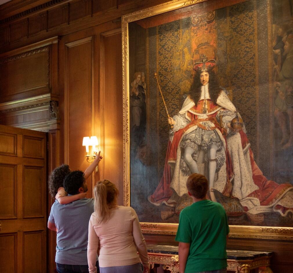 A family looking at the portrait of Charles II by John Michael Wright (RCIN 404951)
