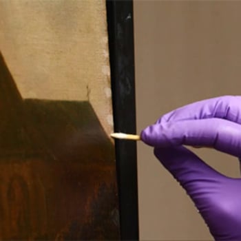 A brush removing varnish from the surface of a painting