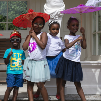 Group of 10 children with parasols in Buckingham Palace gardens